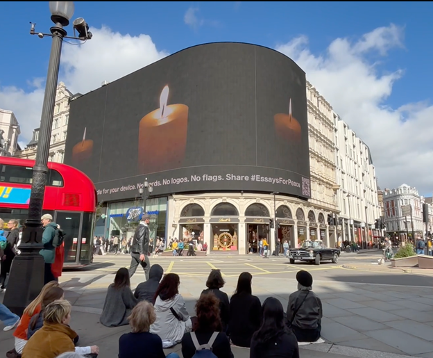 People meditating for peace in front of Piccadilly Circus screen